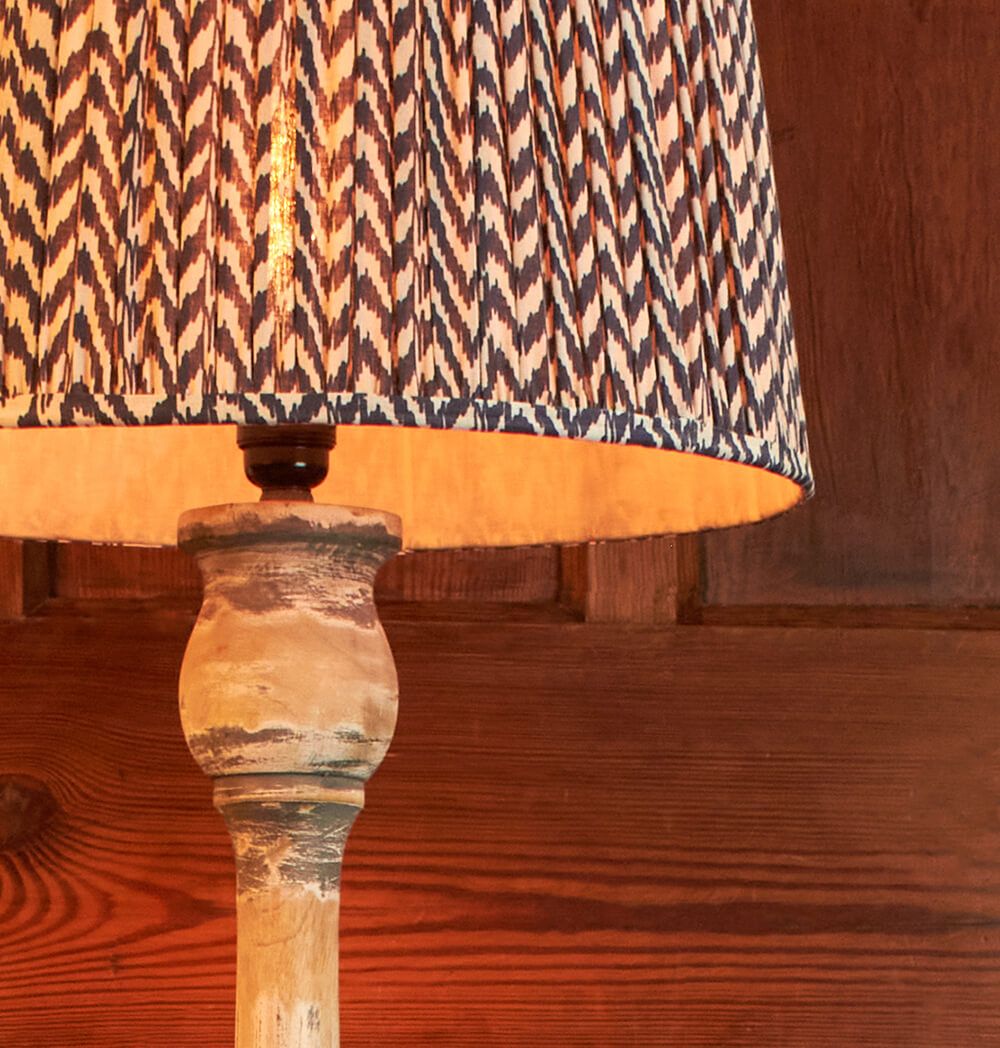 Floor lamp with distressed wooden stand and silk patterned shade