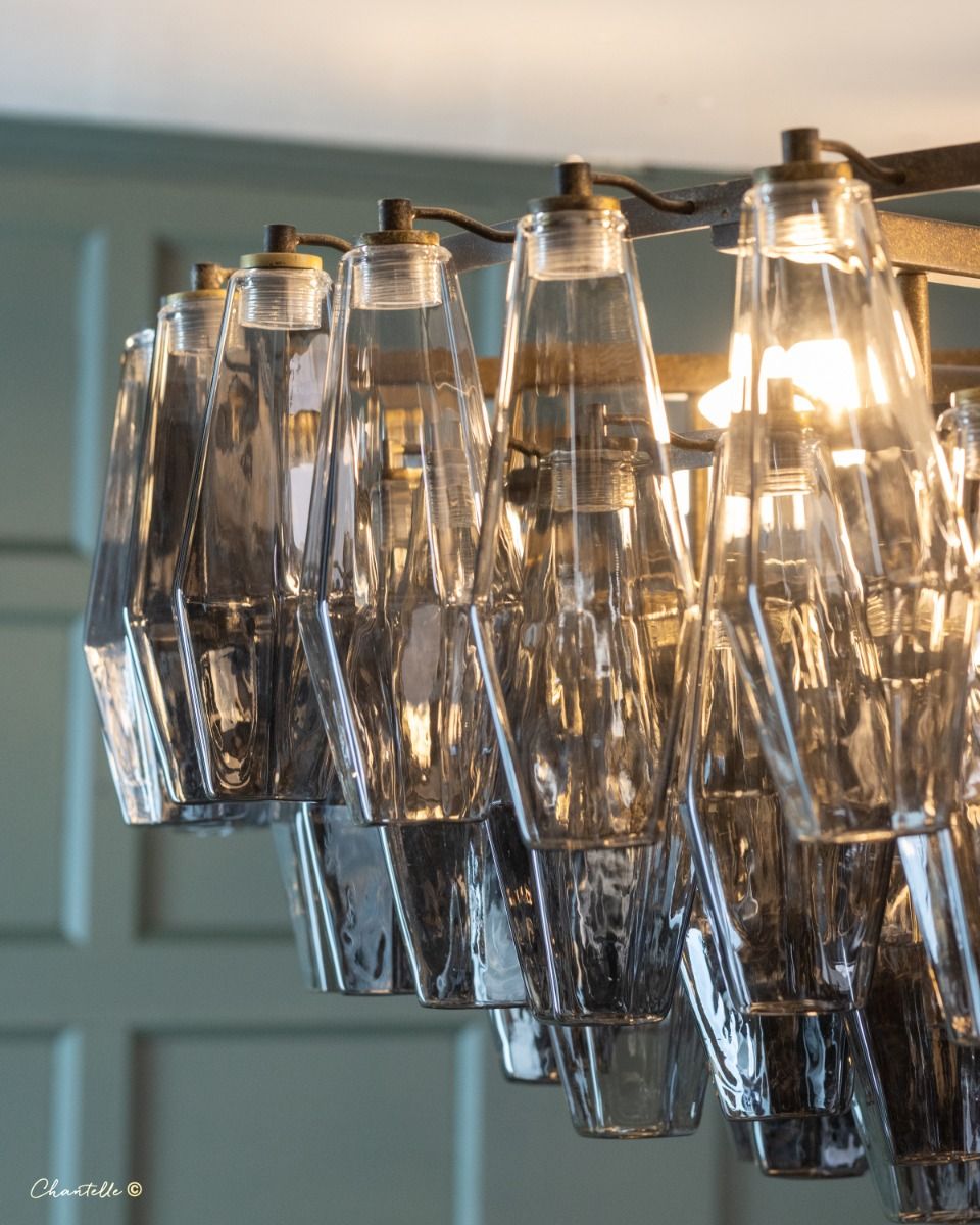 large antique chandelier adorned with bottle shaped smoked glass